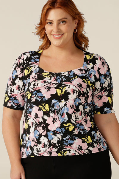 A size 18 plus size woman wears a printed jersey top with short sleeves and square scoop neckline. A good top for full busts, the Berni Top has a structured bust. This top is available to shop online in sizes 8 to size 24.