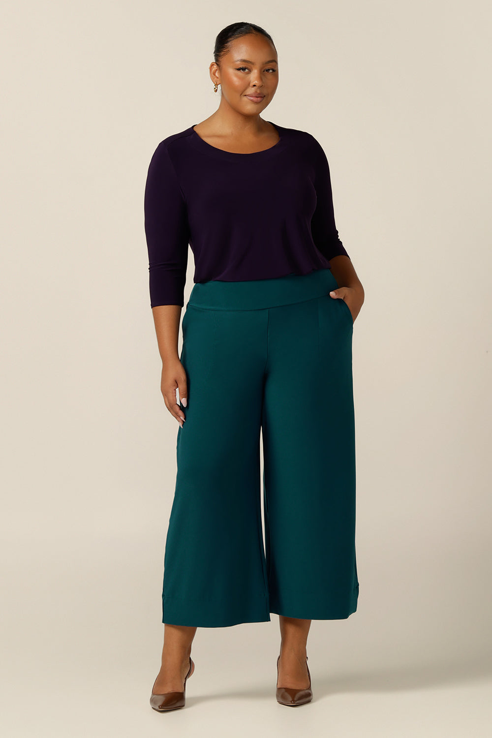 A plus size 18 woman wears Petrol green, wide leg, cropped length, pull on pants by Australian and New Zealand women's clothing brand, L&F. Featuring a pull-on waistband, these stretch jersey trousers are good pants for comfortable corporate wear.