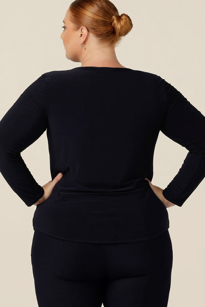 A plus size, size 18 woman wears a navy blue, long sleeve top with a boat neckline that's made in Australia by Australia and New Zealand women's clothing brand, L&F.