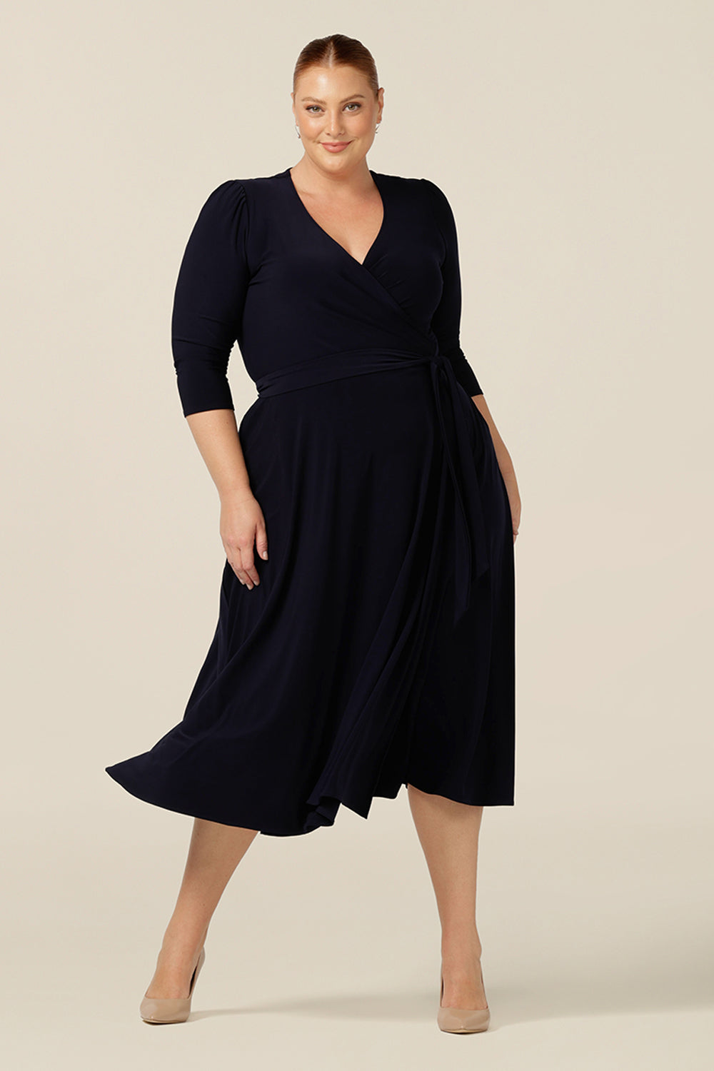 a size 18, fuller figure woman wears a jersey wrap dress in navy blue by Australian and New Zealand womenswear brand, L&F.