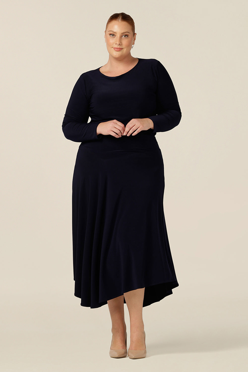 Creating a faux dress look for work and event wear, a long sleeve, boat neck top in navy blue stretch jersey is worn with a navy skirt with asymmetric hemline. 