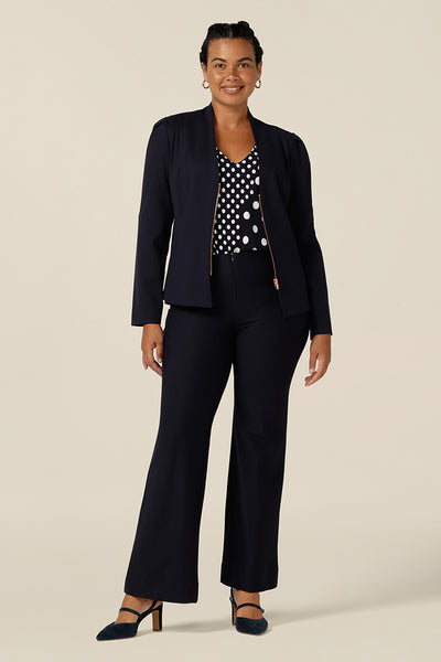Shop this modern corporate look for women - a collarless, navy blue, tailored jacket is worn with navy bootcut leg pants. The jacket has full length sleeves, a rose gold zip fastening and is made in Australia by women's clothing label, Leina & Fleur.