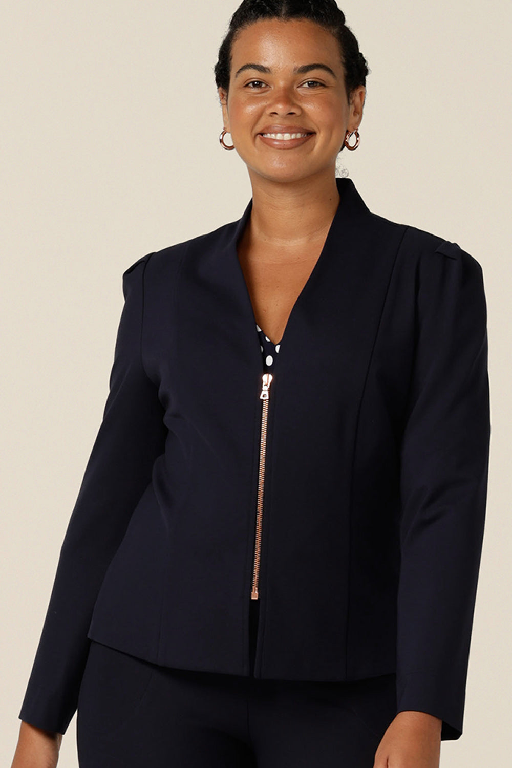 Shop this modern corporate women's jacket online. A collarless, navy blue, tailored jacket with full length sleeves, a rose gold zip fastening is made in Australia by women's clothing label, Leina & Fleur.