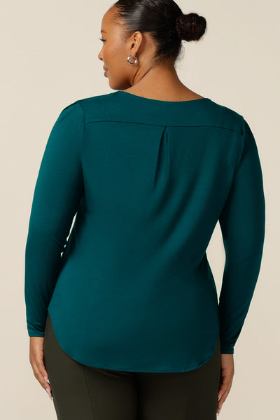 Back view of a size 18 woman wears a round neck, long sleeve, fitted, plus size top in green bamboo jersey. Made in Australia by women's clothing company L&F, this long sleeve top is available to shop online in an inclusive size range of 8-24.