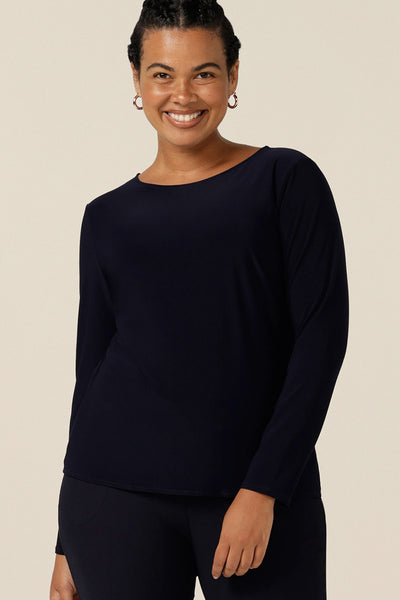 a size 12, curvy woman wears boat neck jersey top in navy blue. A good capsule wardrobe basic, this long sleeve jersey top is easy to wear for casual or workwear style.  