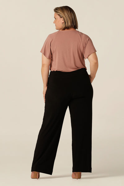 Back view of women's size inclusive work pants. Pictured on a size 8 in black comfortable corporate pants. Full length straight leg pants