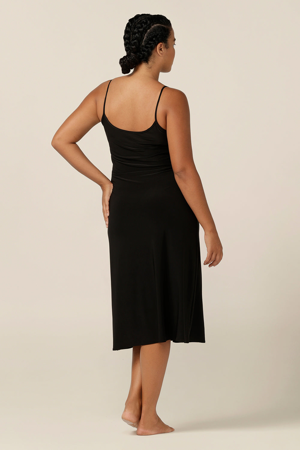 back view of a size 12 woman wearing a below-the-knee length, reversible slip in black, slinky jersey fabric. 
