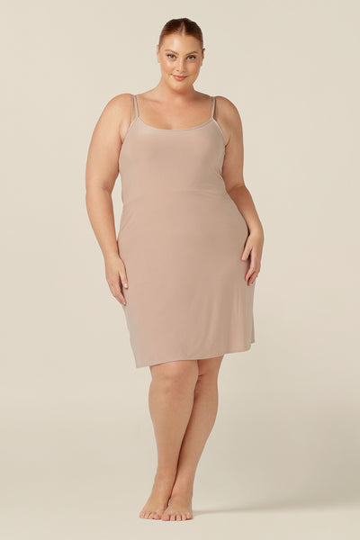 plus size, size 18 woman wears a nude, mini-length slip, shown with a scoop neckline and thin straps.. A reversible slip, this flesh-coloured under garment can have a V-neck or a scoop neck to give a smooth layer under dresses and skirts. Shop Australian womens clothing online