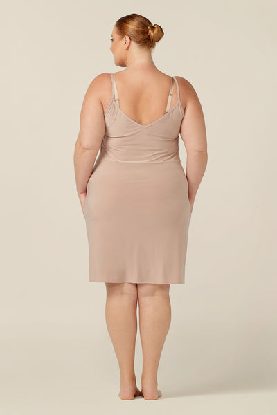 This Australian women's clothing piece is perfect for plus-size women in size 18 who are looking for a comfortable and versatile undergarment. It is a nude mini-length slip featuring a scoop neckline and thin straps that provide a smooth layer under dresses and skirts. Perfect as plus-size loungewear
