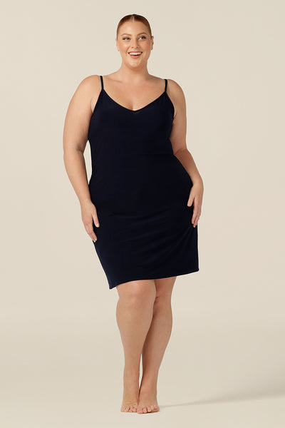 plus size lounge wear - size 18 woman wears a navy, mini-length slip. A reversible slip, this under garment can have a V-neck or a scoop neck to give a smooth layer under dresses and skirts.