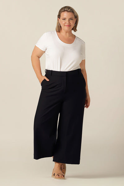 work friendly cropped, wide leg pant with pockets in navyplus size woman wearing work-wear navy wide leg, cropped tailored pant with pockets styled with white bamboo jersey short-sleeve top 