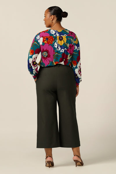  A size 18, plus size woman wears these wide leg, cropped and tailored workwear trousers with floral print long sleeve top. Great for work and casual wear, these  made-in-Australia pants promise comfort and quality.